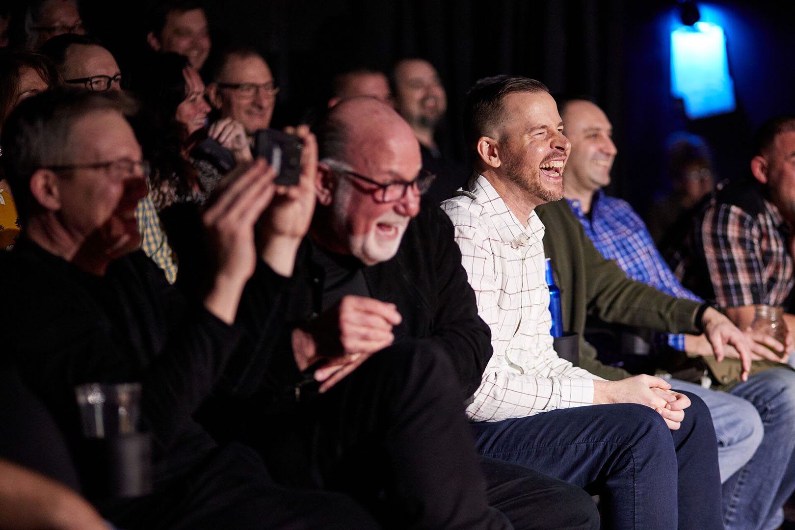 Audience members enjoying a comedy show in an intimate theater